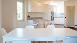 Una cocina moderna con armarios blancos, una mesa de comedor y sillas.