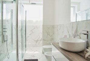 Een douche, een haardroger, een bidet, handdoeken