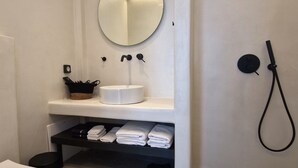A bathroom with a toilet, sink, and shower. - Santozen Suites (Santorini)