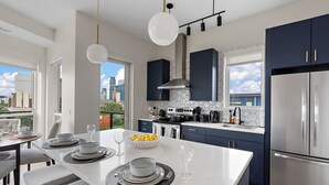 A modern kitchen with a central island, dark cabinets, and stainless steel appliances. - Luxury 2Bd Condo DT Minneapolis, Minutes From Convention Center & US Bank Arena (Minneapolis)
