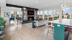A modern living room with a fireplace, a Netflix TV, and a city view. - Luxury 2Bd Condo DT Minneapolis, Minutes From Convention Center & US Bank Arena (Minneapolis)