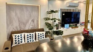 Un salon moderne avec un canapé, une table à manger et un téléviseur.