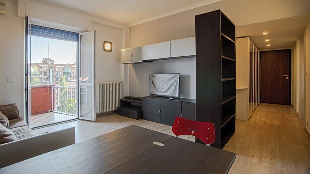 A modern apartment with a balcony, a dining area, and a living space.