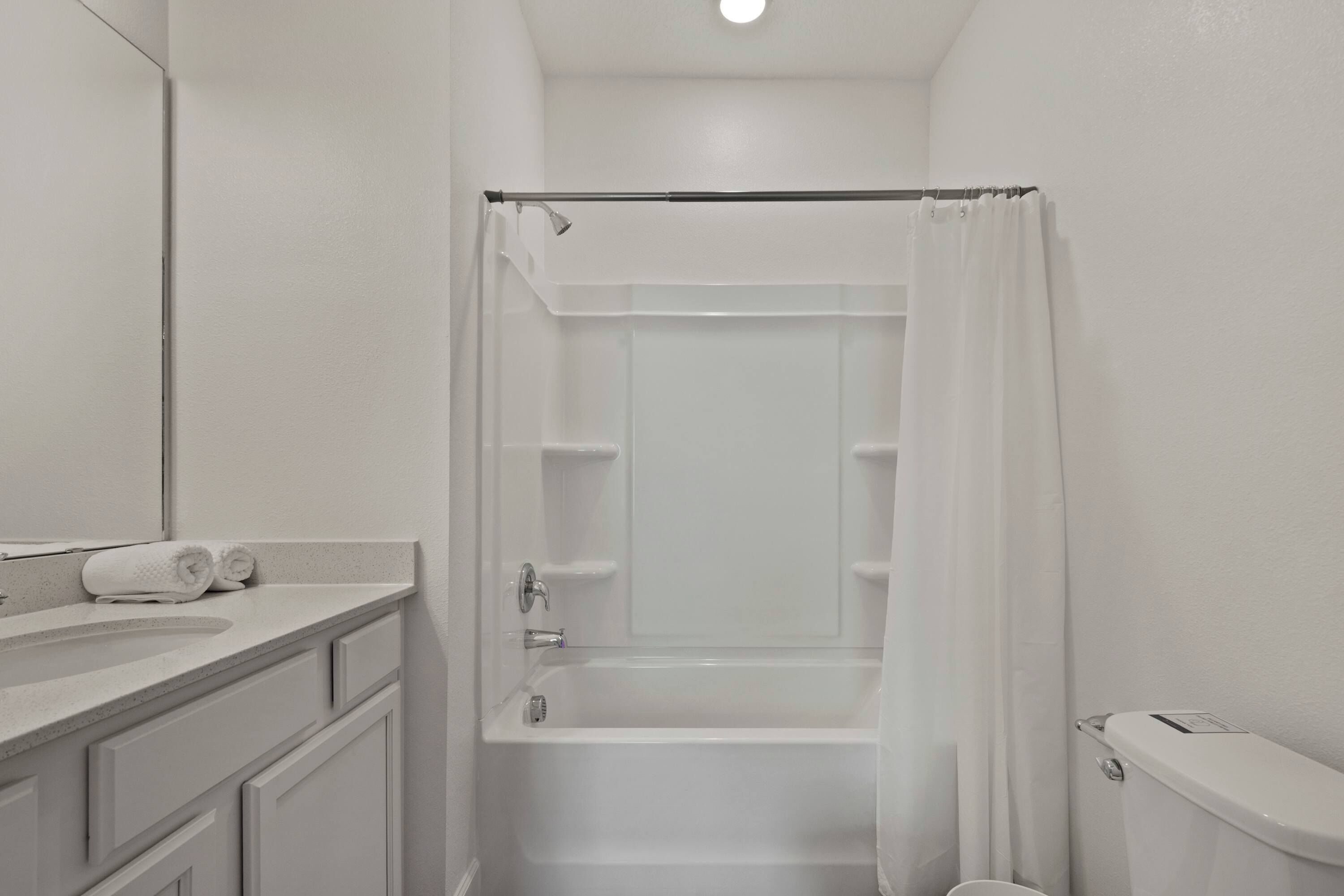 A bathroom with a bathtub, toilet, and a sink.