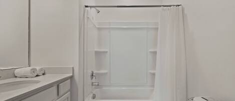 A bathroom with a bathtub, toilet, and a sink.