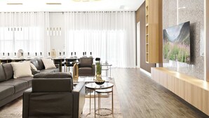 Un salon moderne avec un canapé d’angle, une table basse et un téléviseur fixé au mur.
