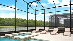 A pool area with a view of a lake, surrounded by a metal frame structure. - Themed Kids' Rooms, Pool & Game Loft Near Disney (Kissimmee)