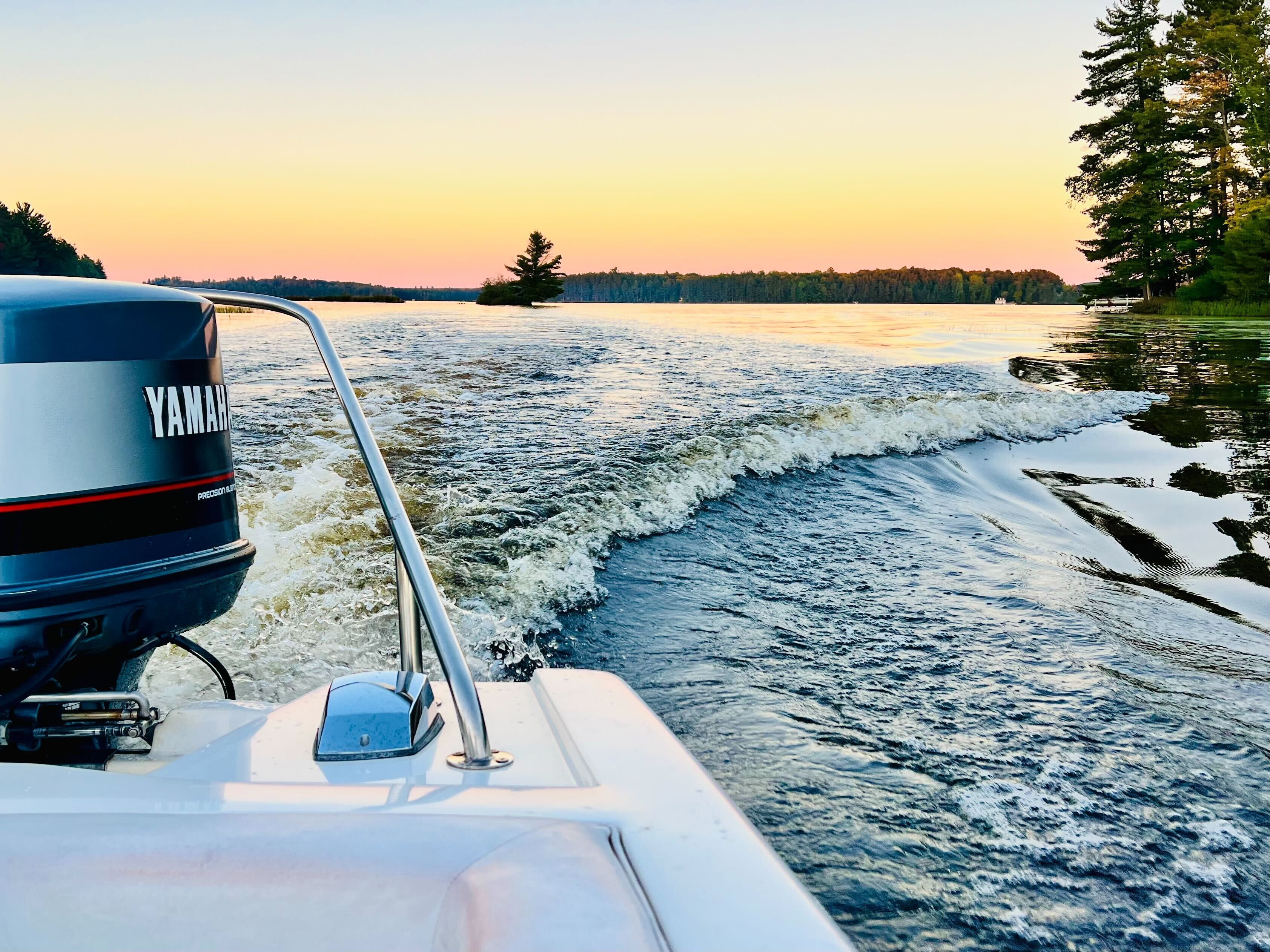 Een boot met een Yamaha buitenboordmotor, waterski's en een golvenpatroon.