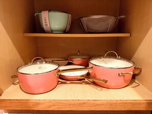A kitchen shelf with various cookware, including pots and pans. - Chicago 1BR Near Lake Michigan & Pratt Beach – Free Parking (Chicago)