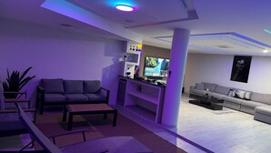 A modern living room with a sofa, a coffee table, and a TV.