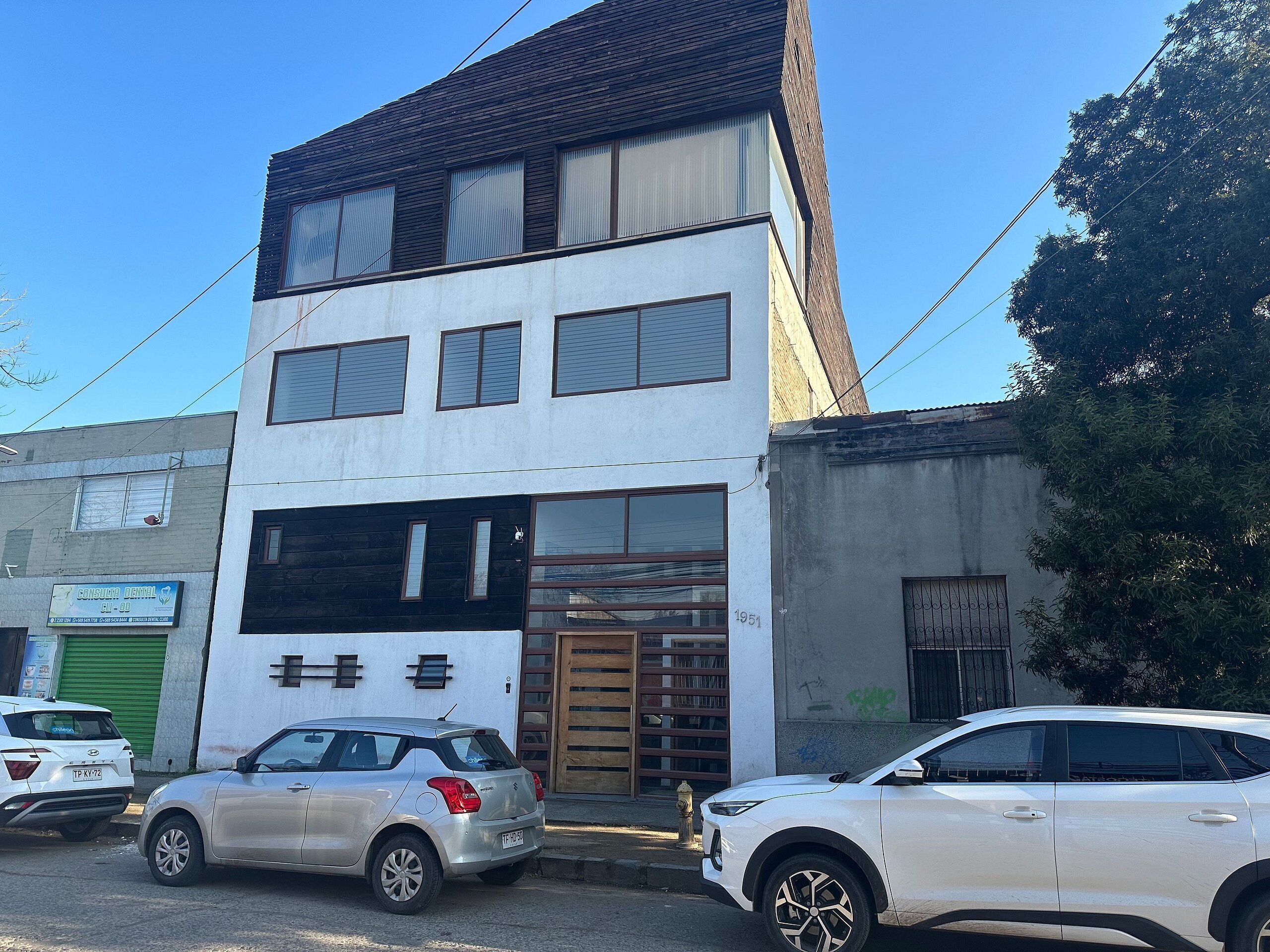 A two-story building with a sign for a dental clinic on the ground floor.
