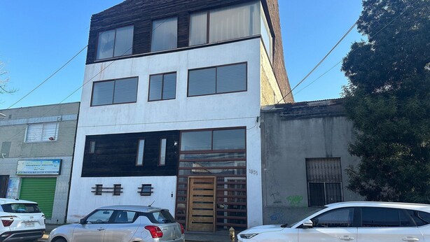 Un immeuble de deux étages, avec une enseigne indiquant un cabinet de dentiste au rez-de-chaussée.