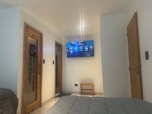 A hotel room with a bed, a television mounted on the wall, and a door labeled "hostel inside". - Hotel Inside (Santiago)