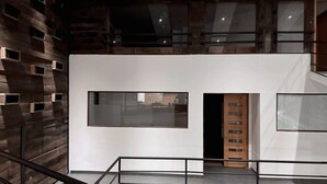 A multi-level interior with exposed brick walls, large windows, and a staircase. - Hotel Inside (Santiago)