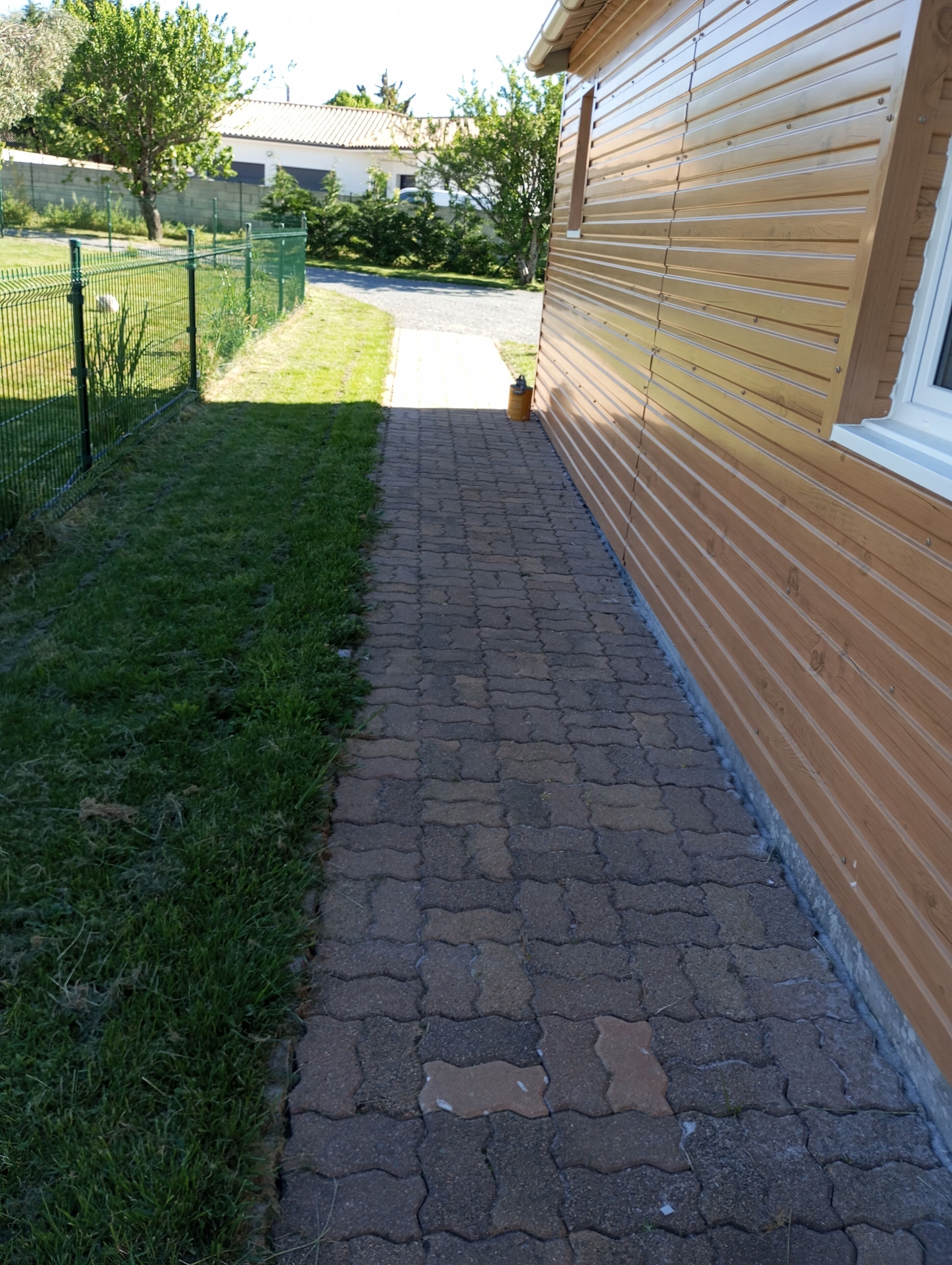 Un chemin pavé mène à un bâtiment dont l’extérieur est en bois.