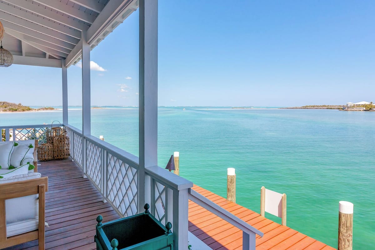 A wooden deck with a view of turquoise waters and a distant shoreline.