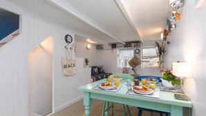 A dining area with a table set for breakfast, a staircase, and a wall with decorative items.