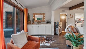 Una sala de estar moderna con un ventanal grande, una chimenea y una zona de estar acogedora.