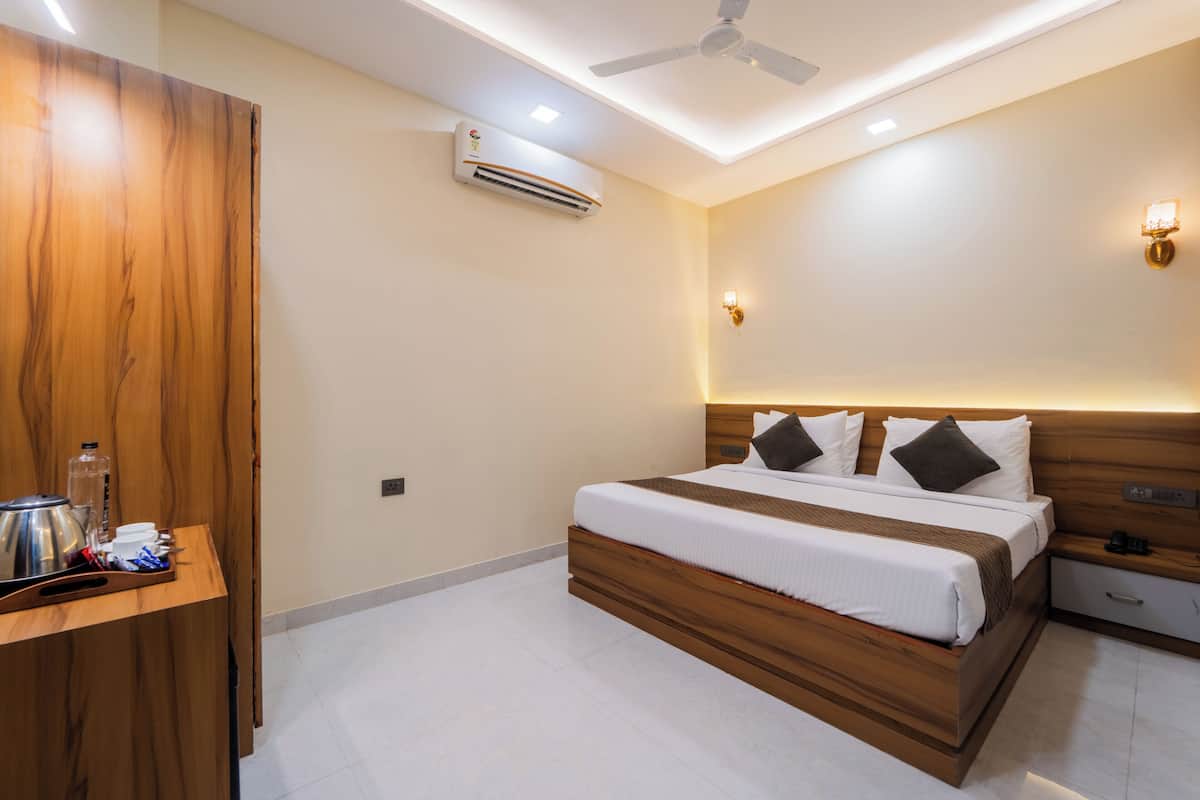 Un dormitorio moderno con una cama de madera, mesitas de noche, un equipo de aire acondicionado y un ventilador de techo.