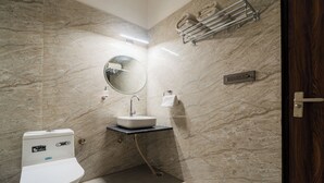 Un baño moderno con inodoro, lavabo y ducha.