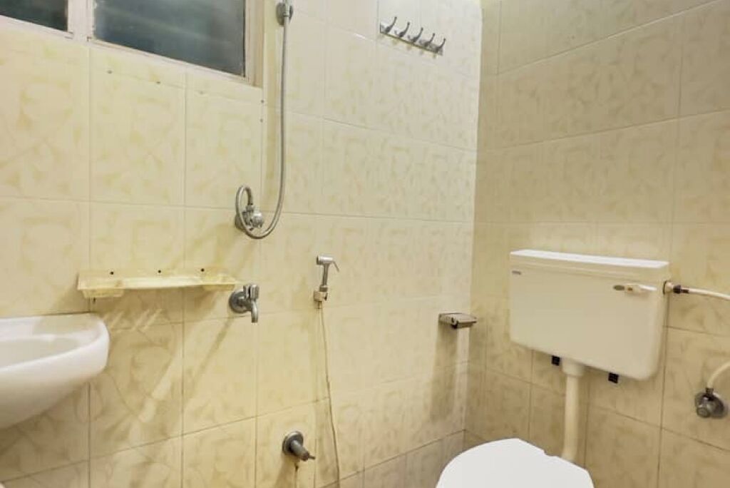 Une salle de bain avec des toilettes, un lavabo et une douche.