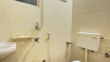 Une salle de bain avec des toilettes, un lavabo et une douche.