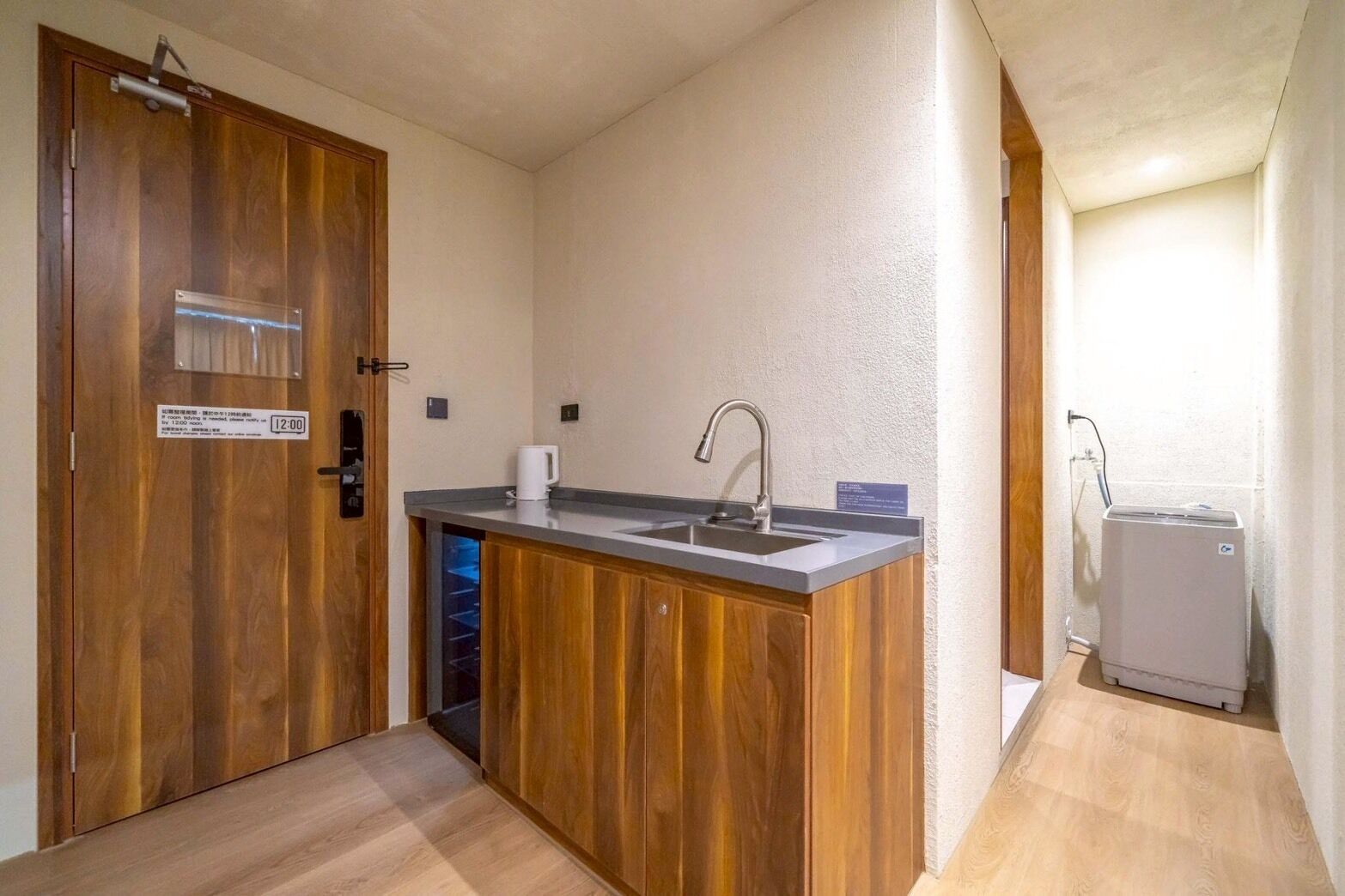 Une cuisine de taille réduite, avec un meuble en bois, un évier et une machine à café.