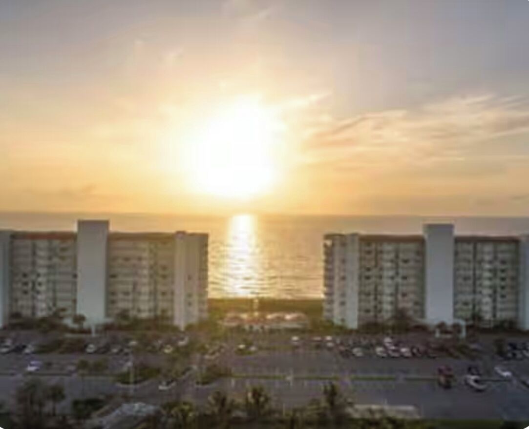 A sunset view over a parking lot with buildings in the background.