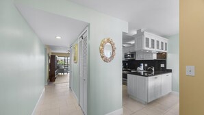 A modern kitchen with white cabinets, a black countertop, and a stainless steel sink.