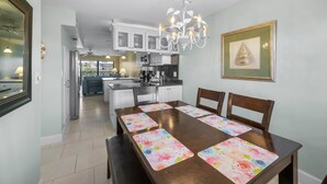 A dining area with a wooden table, chairs, and a chandelier.