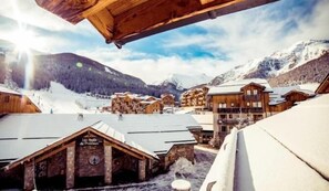 A snow-covered mountain village with wooden buildings and a clear sky.