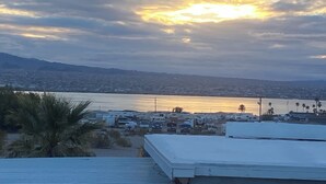 A coastal cityscape with a view of the ocean and distant mountains.