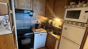 A compact kitchen with a stove, oven, dishwasher, microwave, and sink. - 100m from ski slopes, 6th floor, balcony, tv, ski locker, 61m², Val Thorens (Val Thorens)