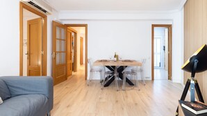 Quarto moderno com uma mesa de jantar, cadeiras, um sofá e uma luminária.