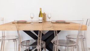 Mesa de jantar com garrafa de vinho, duas taças e pratos.