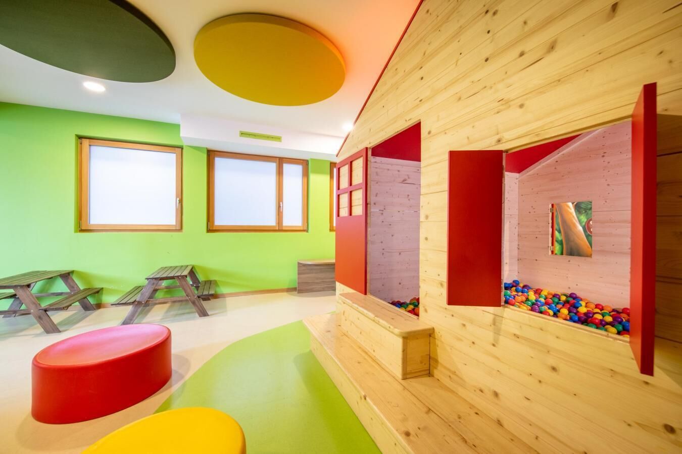 Ein Kinderspielbereich mit Kletterwänden, einer Bällecke und bunten Sitzgelegenheiten.