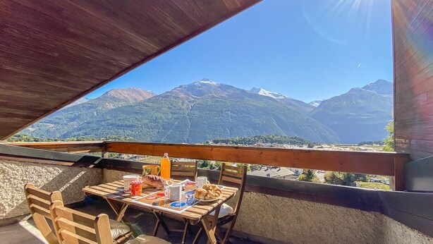 An outdoor dining area with a table set for two, overlooking a mountainous landscape. - 10m from ski slopes, Ground floor, terrace, 27m², Aussois (Aussois)