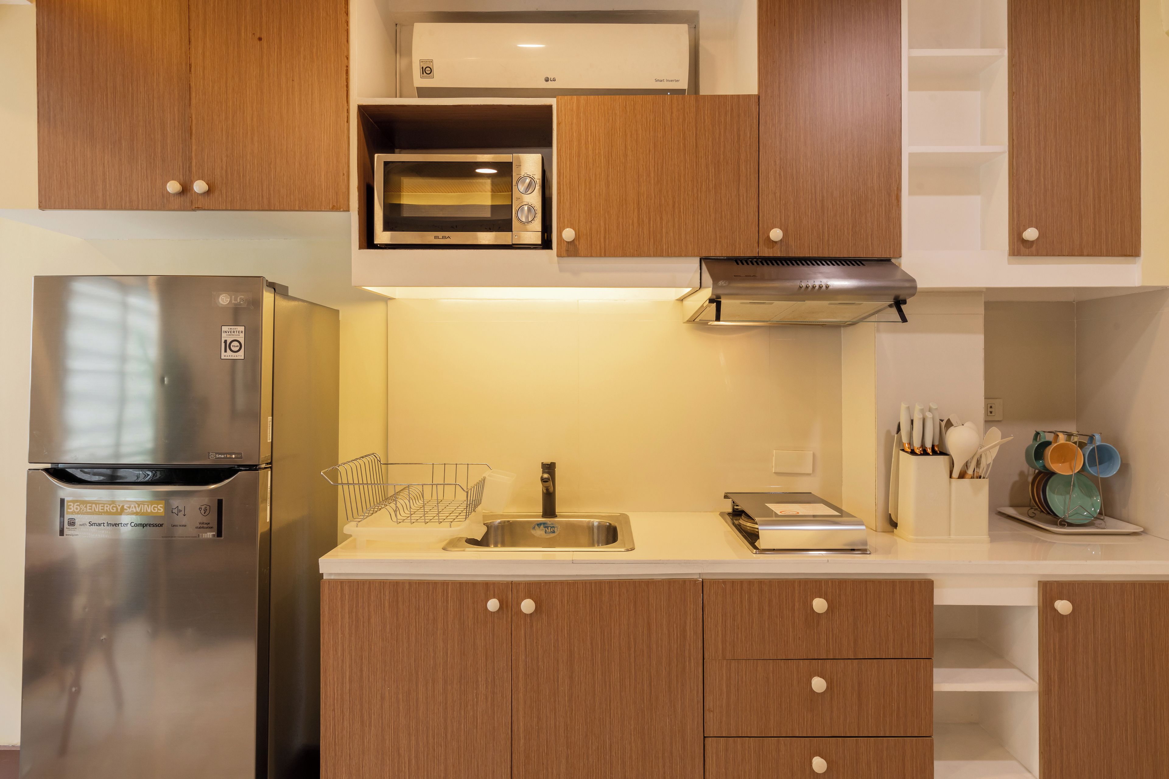 A modern kitchen with a stainless steel refrigerator, an oven, and a microwave.