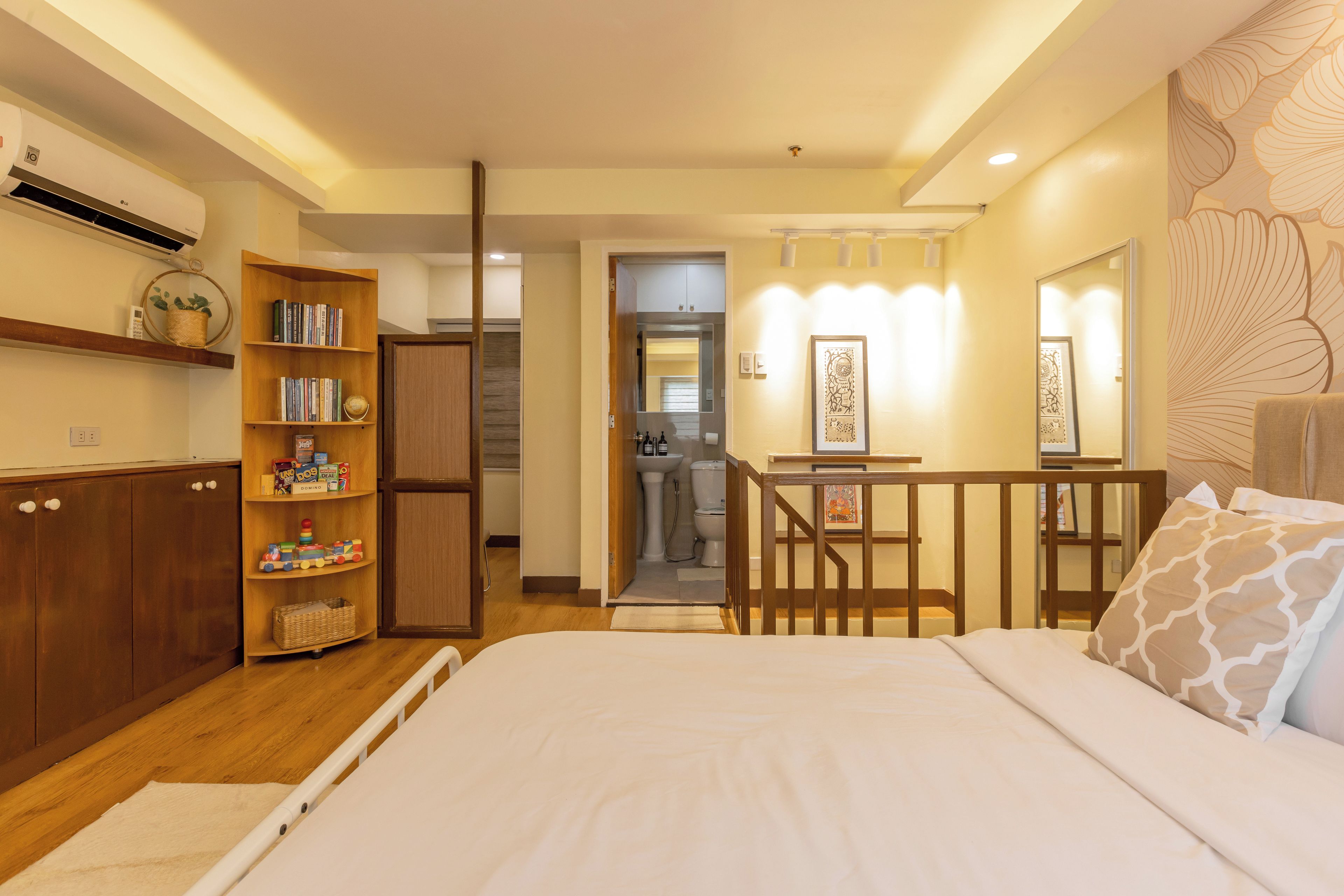 Un dormitorio con cama, armario de madera y estantería.