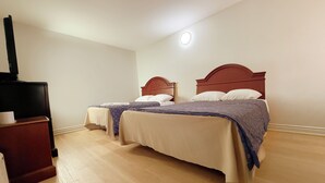 Ein Hotelzimmer mit zwei Betten, einem Fernsehschrank und einer Deckenleuchte.