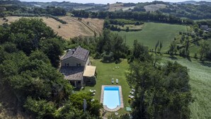 Una casa con piscina rodeada de un paisaje verde exuberante.