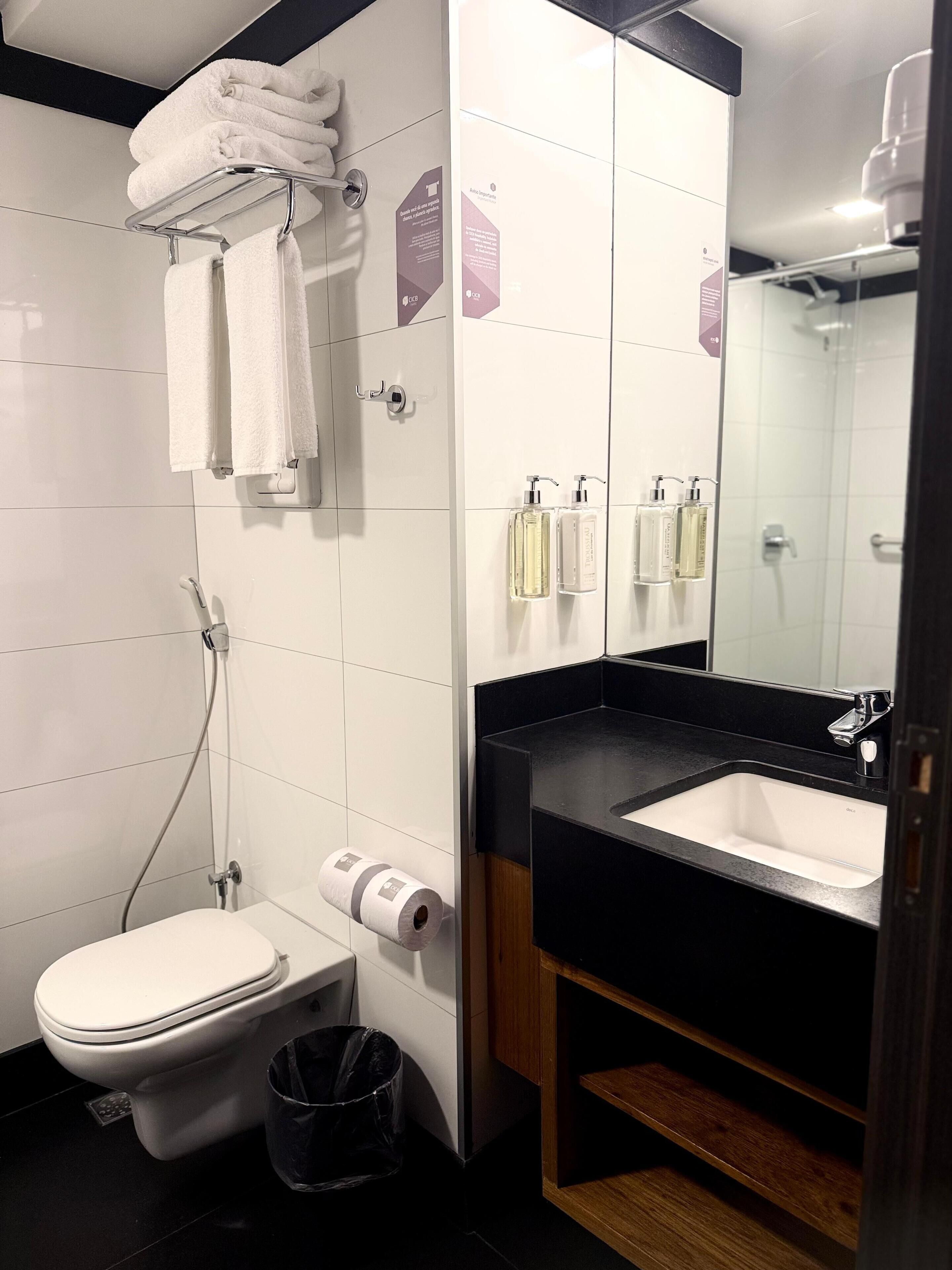 Un baño moderno con inodoro, lavabo y ducha.