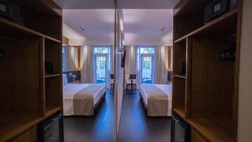 Een hotelkamer met twee bedden, een bureau, een stoel en een televisie.