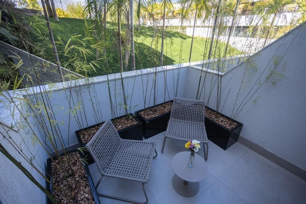 A balcony with outdoor seating, a small table, and potted plants.