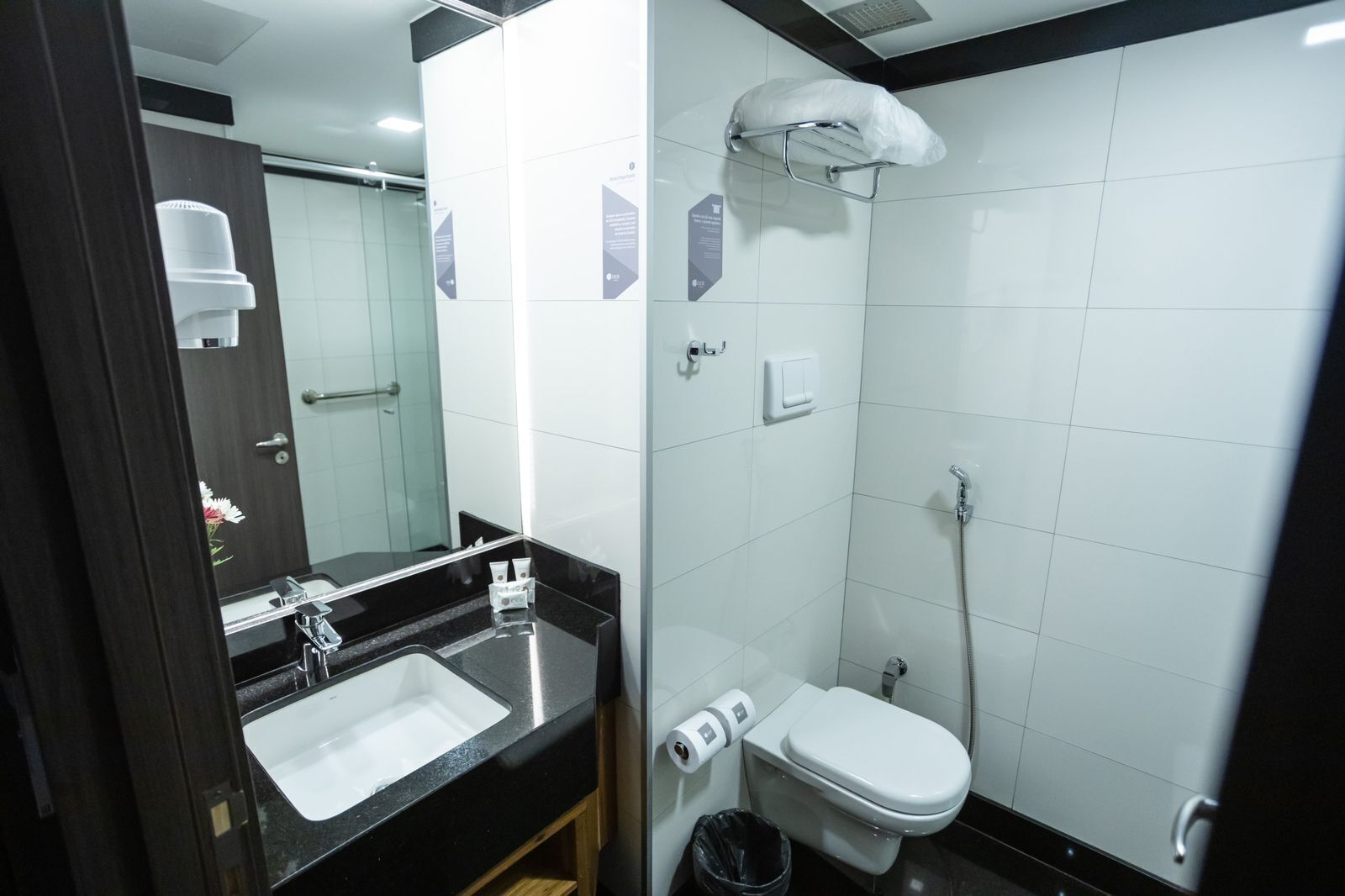 A modern bathroom with a black countertop sink, a white toilet, and a shower area.