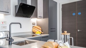 A modern kitchen with a built-in oven, a coffee maker, and a cutting board with lemons. - 42 City Gate - 24-hour Gym Access Included! Sleeps 4 guests in 2 bedrooms (York)