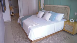 A bedroom with a bed, bedside table, wardrobe, and a mirror. - Relax in front of the sea (Cartagena de Indias)