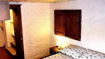 Un dormitorio con una cama, una puerta de madera y un armario empotrado.