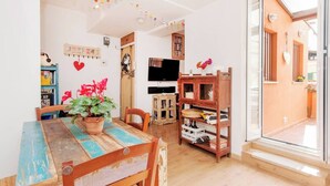 Un rincón comedor acogedor con una mesa y sillas de madera, una planta en maceta y una estantería.