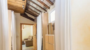 A narrow hallway with wooden cabinets and a sofa in the background. - Charming Luxury Trastevere Apartment (Rome)